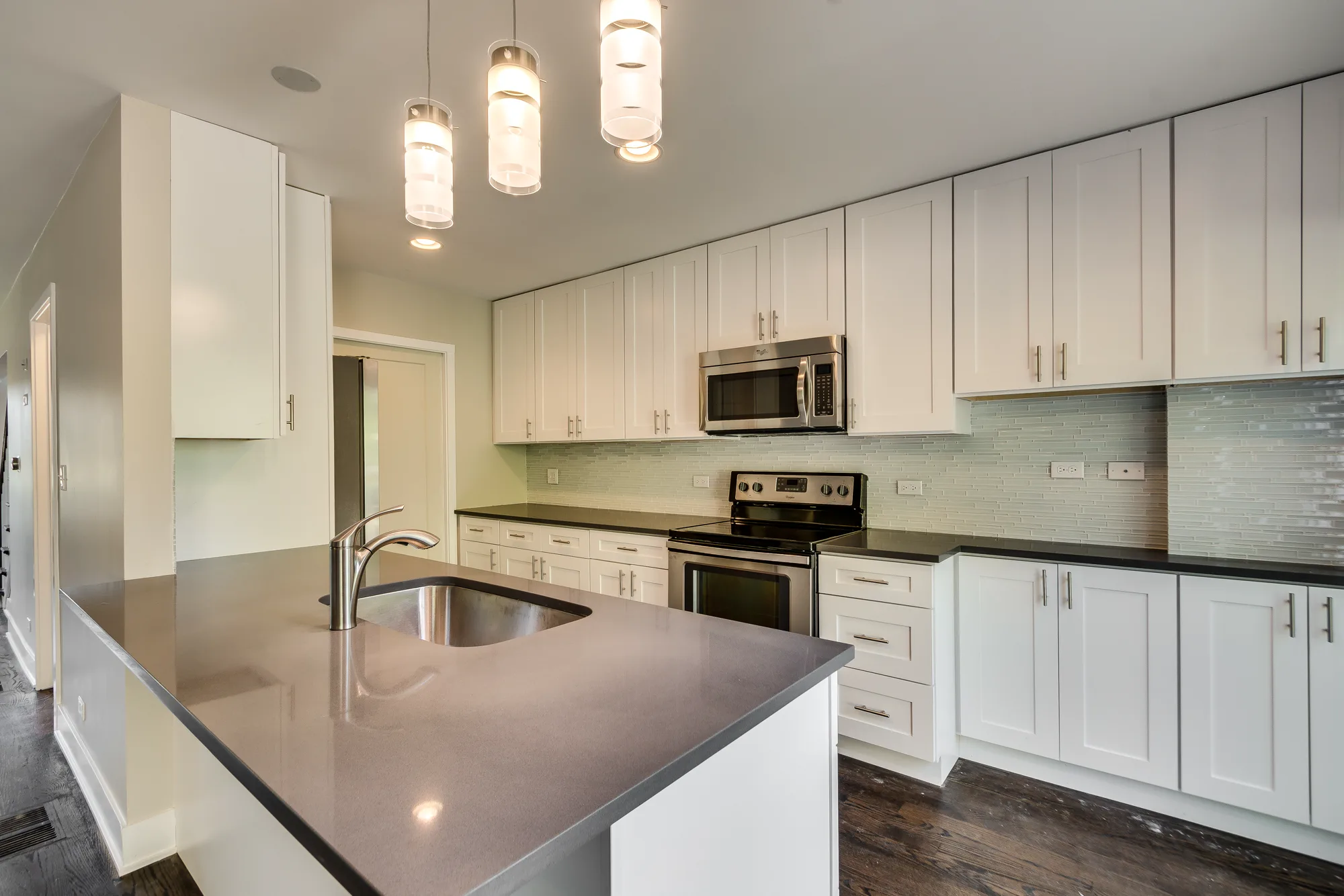 Rehabbed kitchen with quartz island and pendant lighting at Trevian Townhomes