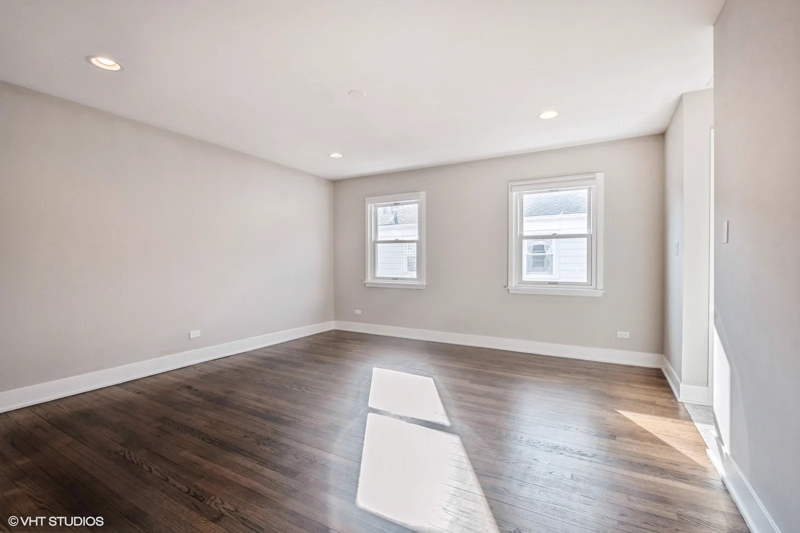 Bedroom with hardwood floors and bright windows