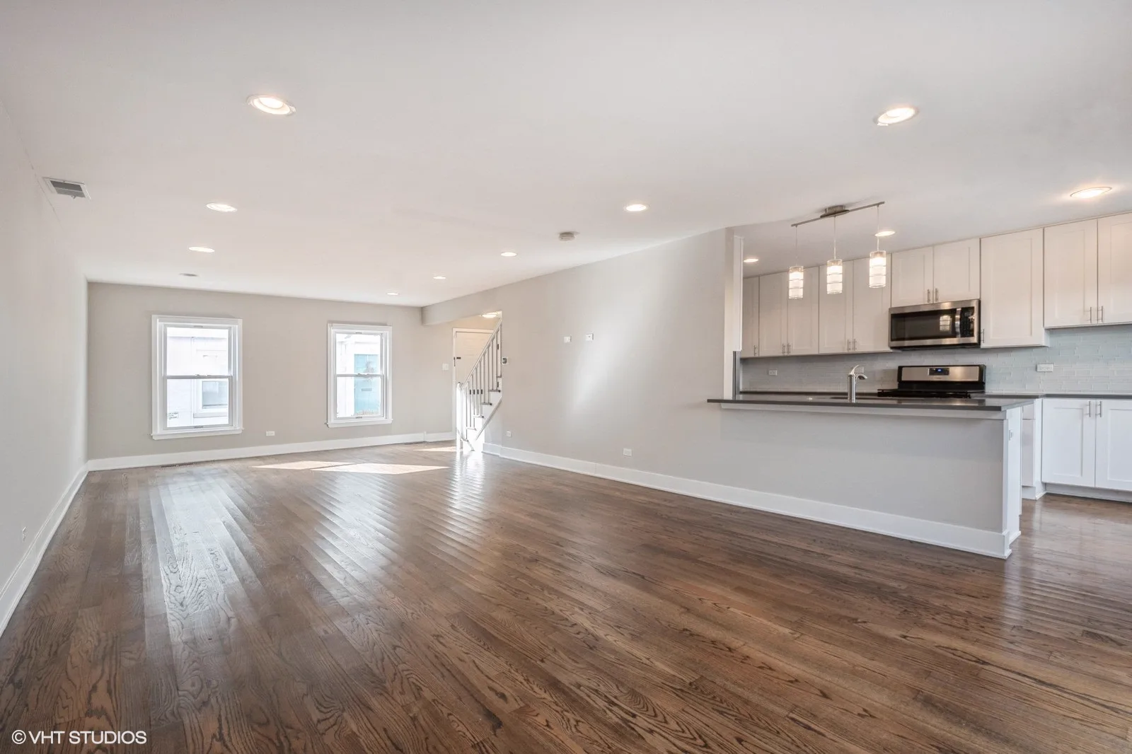 Open living area with kitchen island and hardwood floors